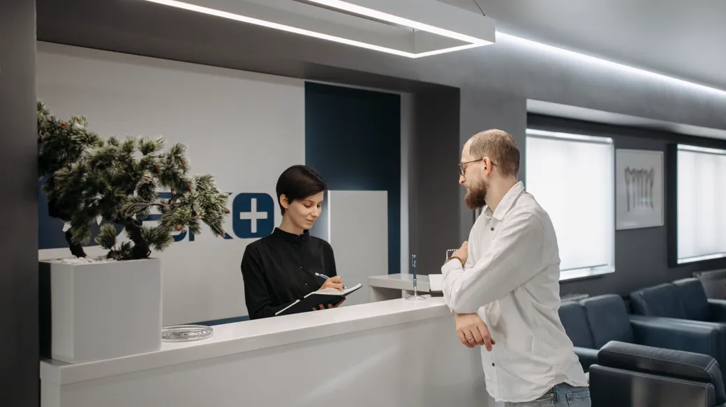Nhân viên lễ tân khách sạn tiếp khách tại quầy