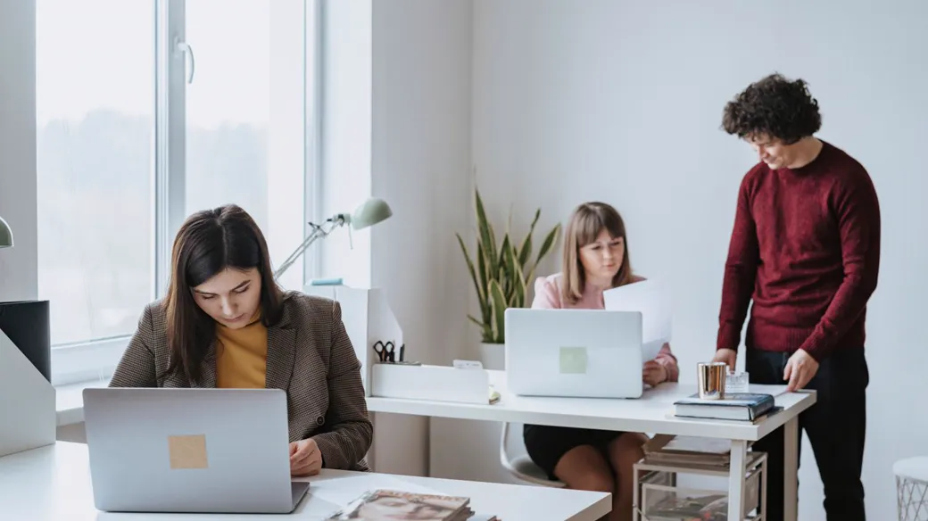 Hai người cùng rà soát chứng từ thu chi trong một văn phòng nhỏ