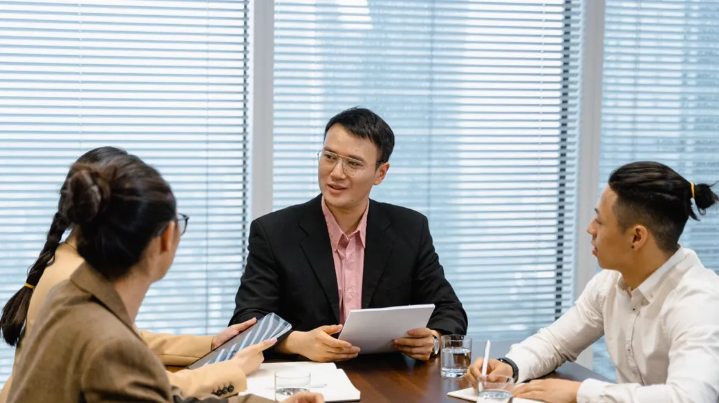 Cuộc họp nhóm quanh bàn trong văn phòng để rà soát thuế, hóa đơn và sổ sách khi hộ kinh doanh lên công ty
